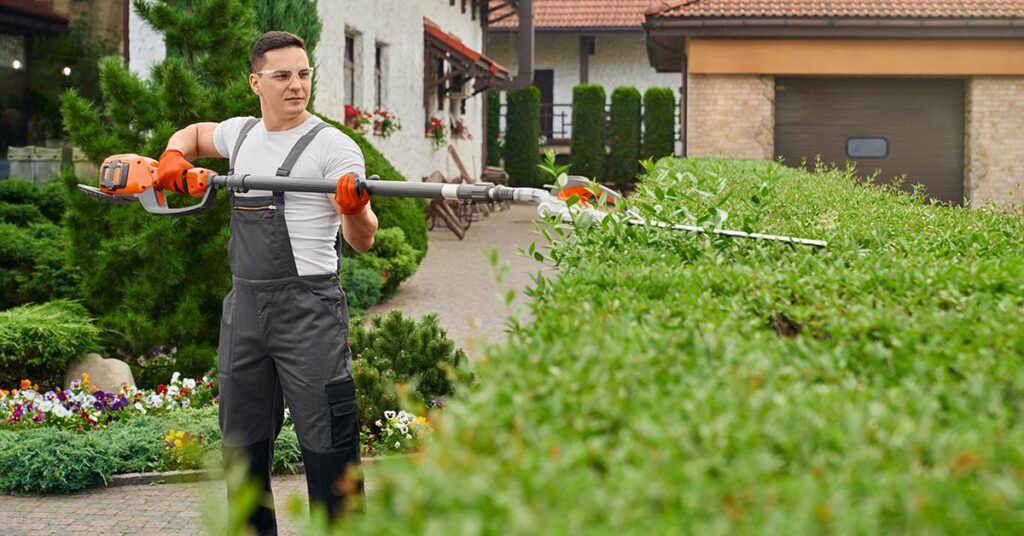 Gardener trimming hedge illustrating HOA landscaping rules