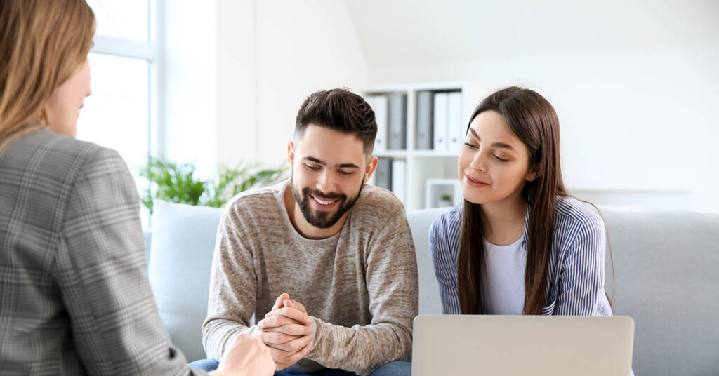 Couple meeting with a real estate agent reviewing HOA estoppel certificate documents before a Florida home closing